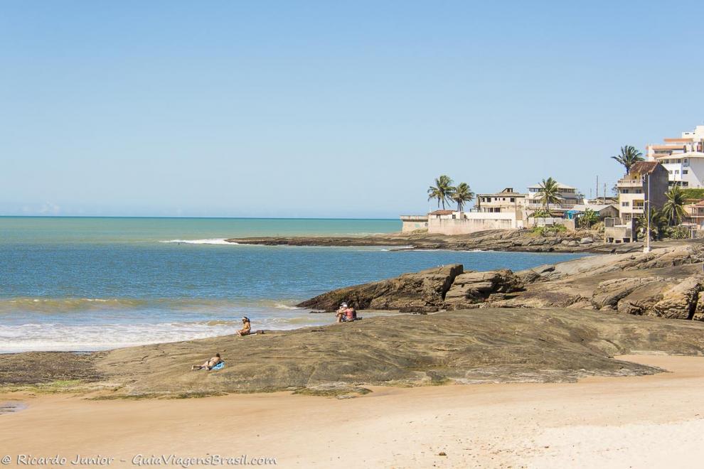 Imagem de pessoas tomando sol no canto da Praia do Morro.